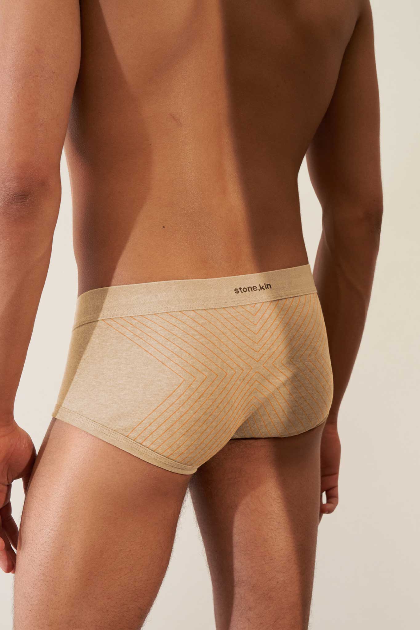 Back view of men's organic cotton trunk in sand color with orange cross, featuring a GOTS certified design for comfort.