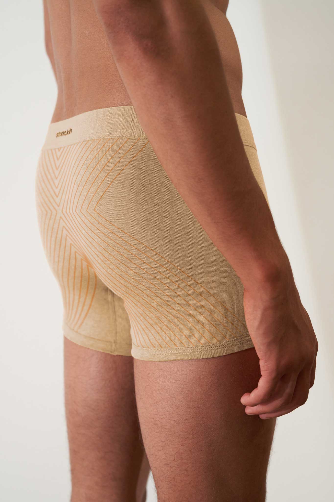 Boxer briefs in organic cotton rib, sand melange with orange cross, showcasing comfort and GOTS certified non-toxic fabric.